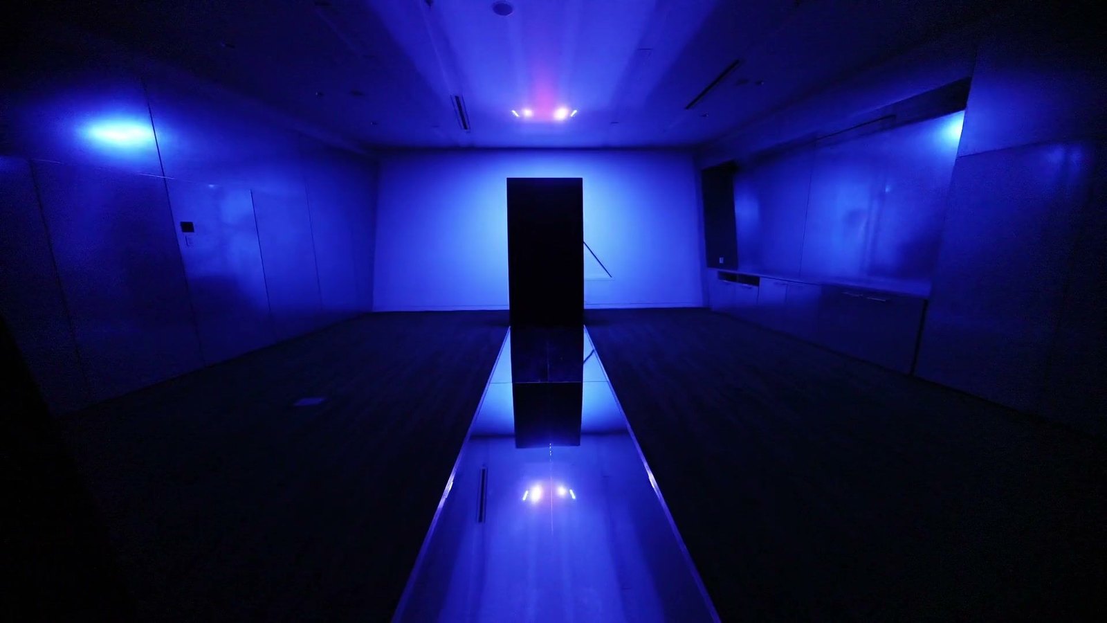 Creative Pulse running at the Contemporary Jewish Museum — laser points pulse across the ceiling and in the mirrored catwalk that runs to the black acrylic column