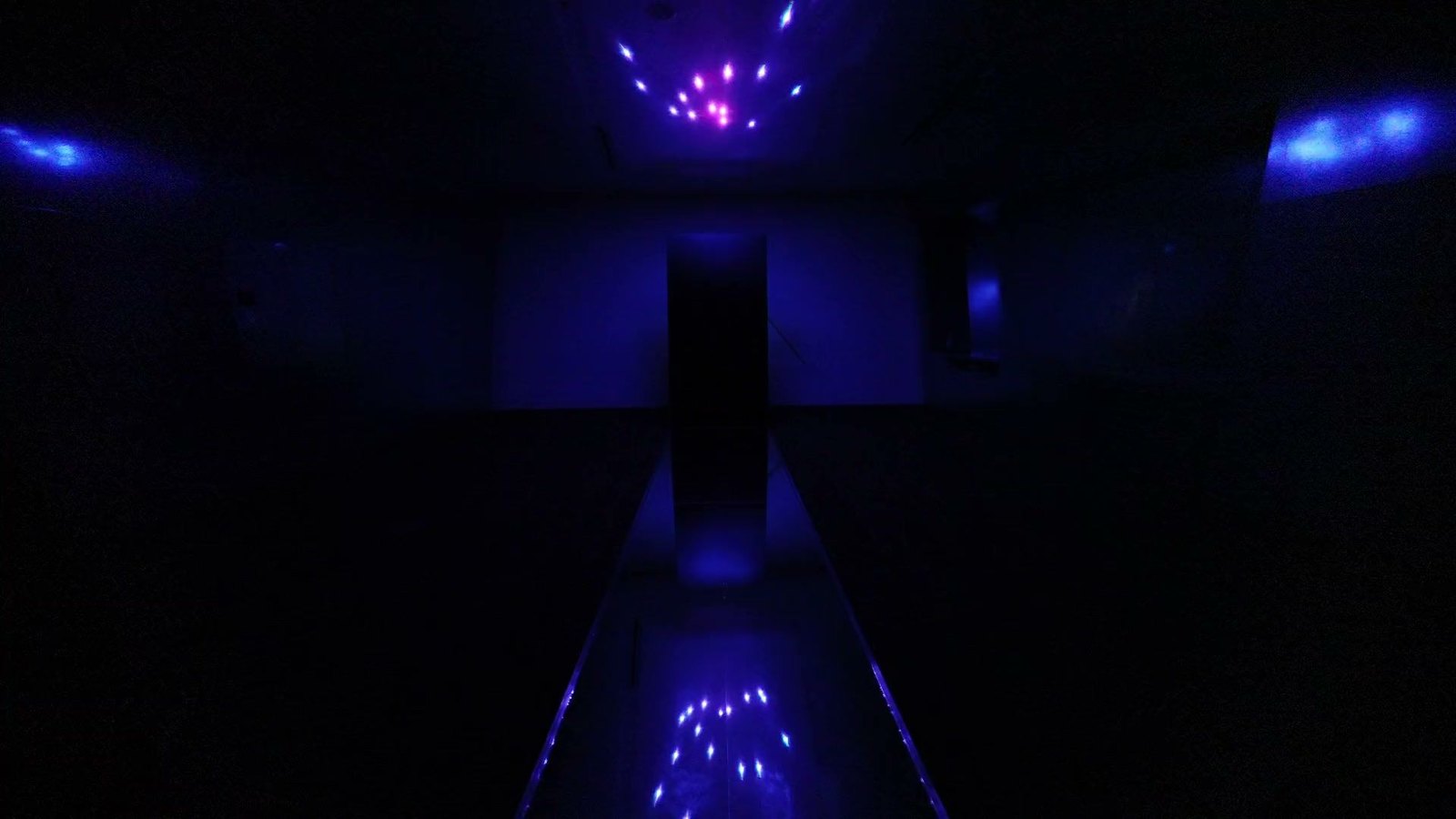 Creative Pulse running at the Contemporary Jewish Museum — laser points pulse across the ceiling and in the mirrored catwalk that runs to the black acrylic column
