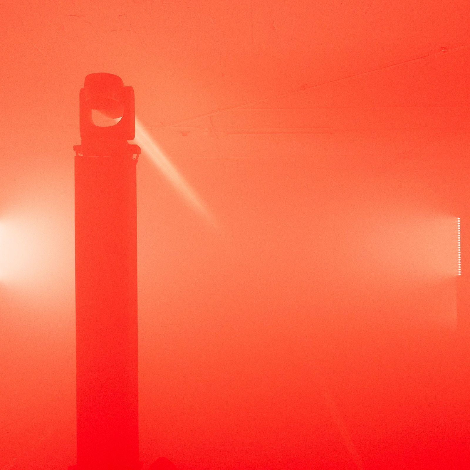 FieldWash at SVN West — the central truss and moving head in silhouette against two glowing wall panels in dense red fog