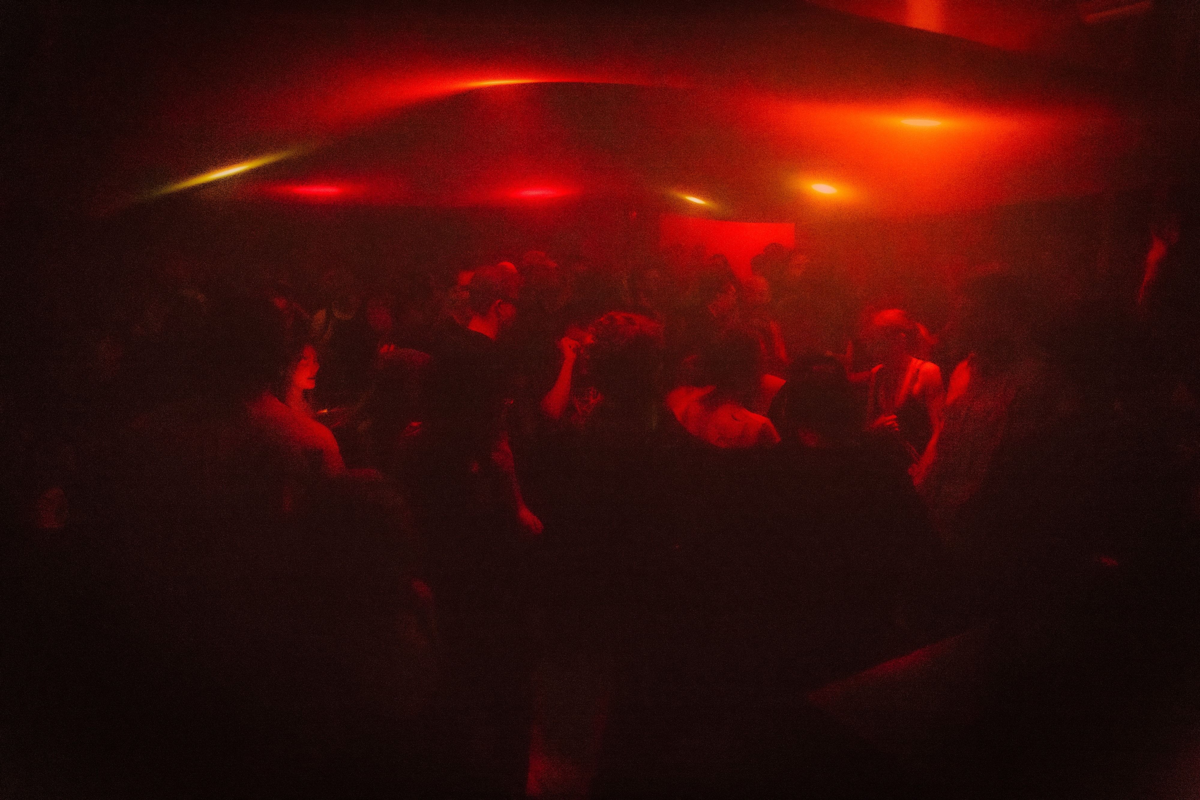 The same crowd under a deep red and orange wash, warm highlights running along the fabric