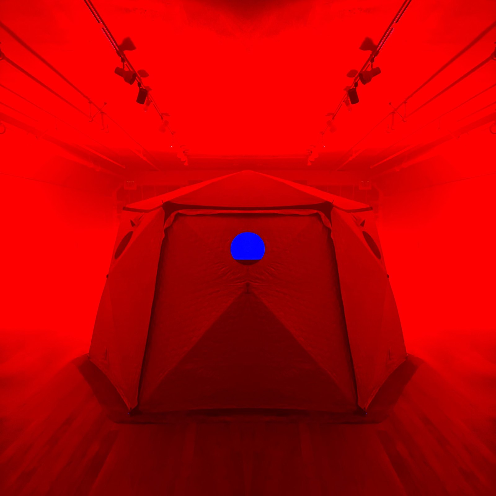 Inside HoloDome1, the Shiftpod tent lit solid red with a single blue light on its far wall